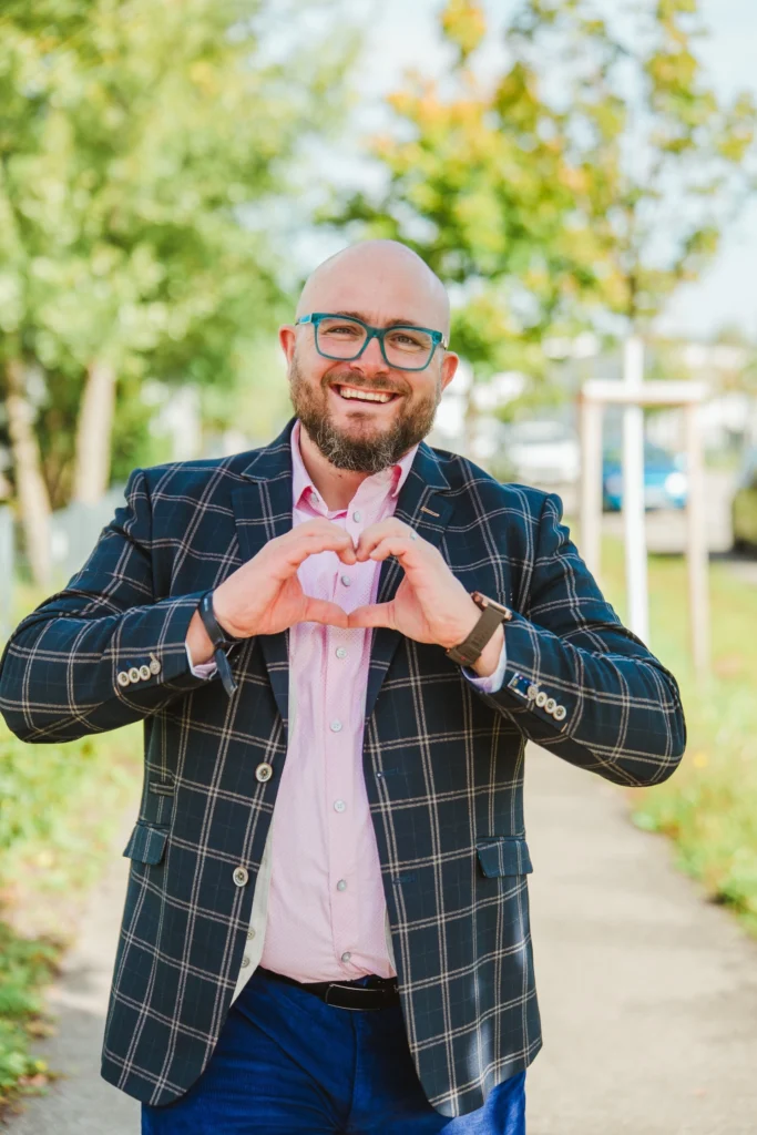 Fuehrungskraefte-Coach Dominik Braun Portrait mit Herz-Geste
